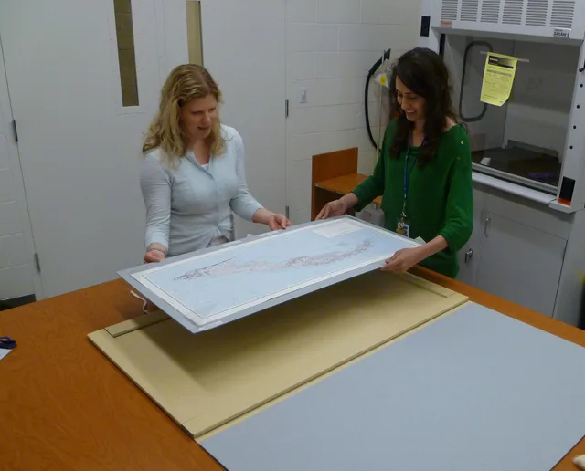 Museum specialist Heather Joines and archivist Stacey Chandler examine a map of Cuba annotated by John F. Kennedy during the Cuban Missile Crisis. The document was on display in the JFK Library Museum for the Cuban Missile Crisis anniversary exhibit; Location: John F. Kennedy Presidential Library, B. Washington D.C. Archives: Speech Verification Basics